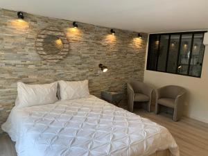 ein Schlafzimmer mit einem weißen Bett und einer Ziegelwand in der Unterkunft Marseille City Chambres&Appartements in Marseille