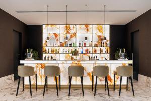 een bar met vier stoelen voor een balie bij Áurea Ana Palace by Eurostars Hotel Company in Boedapest