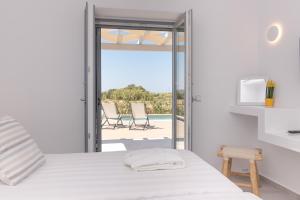 Isalos Villas Naxos في ناكسوس تشورا: غرفة نوم مع سرير وإطلالة على المحيط