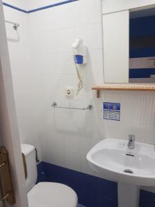 a bathroom with a white toilet and a sink at Hostal Termes in Sitges