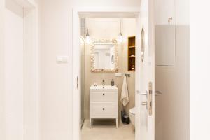 een witte badkamer met een wastafel en een toilet bij Apartamenty In Patio Jurata in Jurata