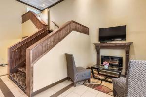 sala de estar con escalera, chimenea y TV en Econo Lodge Quakertown, en Quakertown