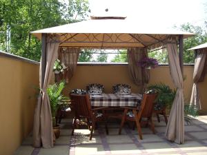 een prieel op een patio met een tafel en stoelen bij Отель Корона in Dnipro