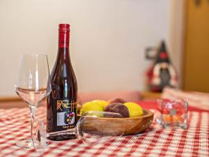 uma garrafa de vinho e uma taça de fruta numa mesa em Ciasa Lino Sas da le Undesc em Pozza di Fassa