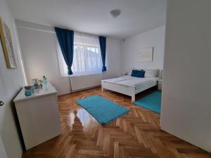 sala de estar con cama y alfombras azules en Apartman Nataly, en Varaždin