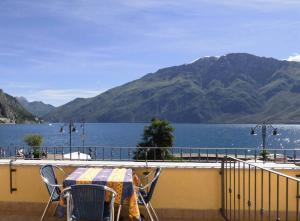 un tavolo e sedie su un balcone con vista sul lago di Hotel Sole - Limone a Limone sul Garda