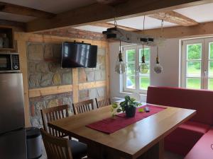 une cuisine avec une table en bois et une télévision murale dans l'établissement Ferienhaus Schloßblick, à Quedlinbourg