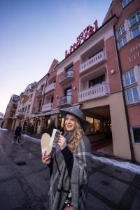 een vrouw neemt een foto voor een gebouw bij Hotel Litovel in Luhačovice