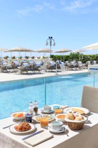 a table with food on it next to a swimming pool at Hotel Cavalieri Palace in Lido di Jesolo