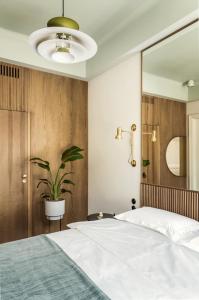 a bedroom with a large bed and a potted plant at Angelus Apartments in Kraków