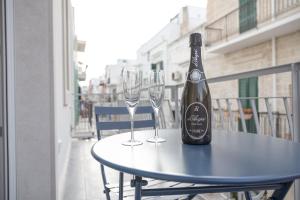 una botella de vino en una mesa con dos copas de vino en B&B Nel Blu Dipinto Di Blu, en Polignano a Mare