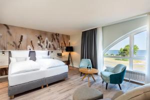 pokój hotelowy z łóżkiem i dużym oknem w obiekcie Aedenlife Hotel & Resort Rügen w mieście Trent