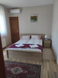 a bedroom with a large bed with a rug at Maros Vendégház in Mórahalom