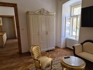 a living room with a chair and a cabinet at Apartmány Svätá Barborka in Banská Štiavnica