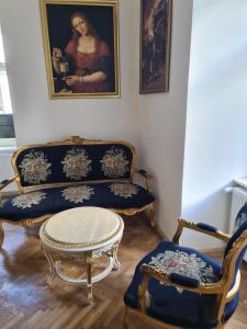 a living room with two chairs and a couch and a painting at Apartmány Svätá Barborka in Banská Štiavnica