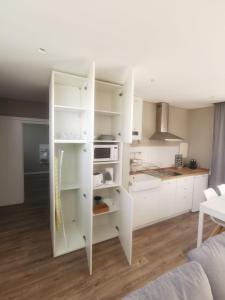 a white kitchen with white cabinets and a kitchen counter at Pateo 780 in Vila Nova de Gaia