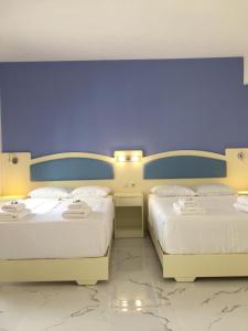 - 2 lits dans une chambre dotée d'un mur violet dans l'établissement Augusta Methoni Hotel, à Methoni