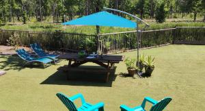 - une table de pique-nique avec des chaises et un parasol bleu dans l'établissement Chalet prestige au coeur du Bassin d'Arcachon, à La Teste-de-Buch