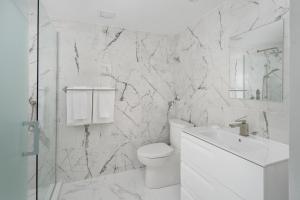 bagno bianco con servizi igienici e lavandino di Sonder Saint Paul a Montréal