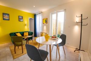 sala de estar con mesa y sillas en Chez Emile Le Jaune Vendée - T2 renové - Terrasse, en Niort