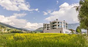 un edificio in cima a una collina con un campo di Bellevue Bruneck - Suites & Lofts a Brunico