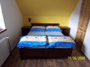 a bedroom with a bed with blue and white pillows at Penzion Silverado in Horní Bečva