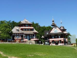 a large house with two turrets on a green field at Penzion Silverado in Horní Bečva