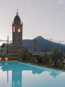 ein Gebäude mit einem Uhrturm neben einem Pool in der Unterkunft Casa Olea Hotel in Cremia