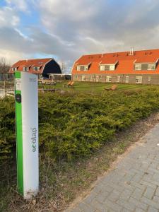 znak w trawie obok budynku w obiekcie Nieuw Leven Texel w mieście Den Burg