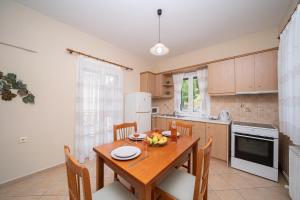 a kitchen with a wooden table and chairs in a kitchen at Maria's Apartments in Sami