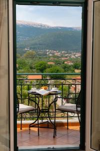 a table and chairs on a balcony with a view at Maria's Apartments in Sami