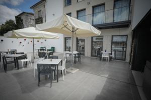 eine Terrasse mit Tischen und Sonnenschirmen auf einem Gebäude in der Unterkunft Casa Das Condessinhas in Lousã