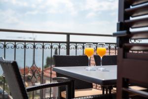 - deux verres de jus d'orange sur une table sur un balcon dans l'établissement Apartments Amigos, à Podstrana