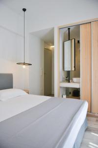 una camera con letto bianco e bagno di Princess Mare Hotel - Adults Only a Naxos Chora