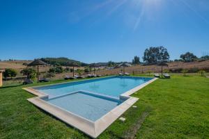 una piscina en medio de un campo de césped en Ares do Monte - Turismo Rural, en Cercal