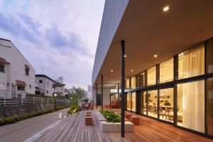 an external view of a building with benches on a sidewalk at MUSTARD HOTEL SHIMOKITAZAWA in Tokyo