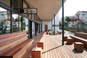 a building with wooden benches and a building with windows at MUSTARD HOTEL SHIMOKITAZAWA in Tokyo