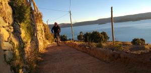 un hombre montando una bicicleta por un camino de tierra en Amantani Lodge, en Ocosuyo