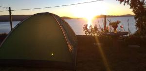 una tienda sentada junto a una mesa frente a un lago en Amantani Lodge, en Ocosuyo