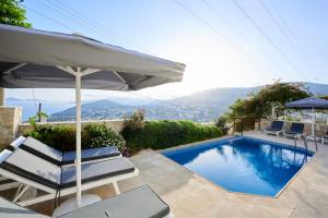 einen Pool mit 2 Stühlen und einem Sonnenschirm in der Unterkunft Luxus Villa Skyla mit 5 Schlafzimmern & Meer-Blick in Kaş