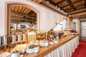 a buffet line with food in a restaurant at Hotel Alpina in Obertauern