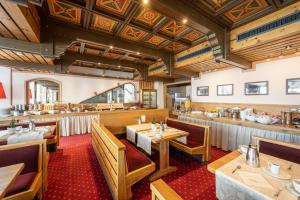 a dining room with wooden tables and chairs at Hotel Alpina in Obertauern