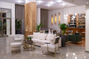 een woonkamer met een witte bank en stoelen bij My Way Hotel & Events in Patra