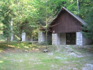 een klein stenen huis midden in een bos bij Camping Pivka Jama Postojna in Postojna