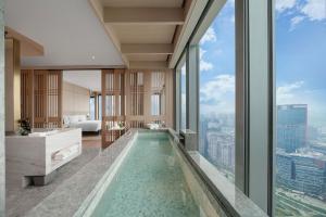 - une salle de bains avec une piscine au milieu d'un bâtiment dans l'établissement Grand Bay Hotel Chengdu, à Chengdu