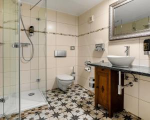 La salle de bains est pourvue d'un lavabo, de toilettes et d'une douche. dans l'établissement Villa Salve, à Binz