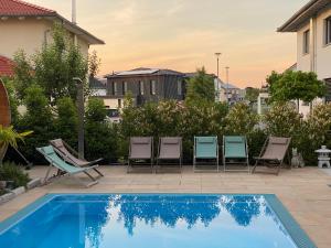 a group of chairs sitting next to a swimming pool at AVALON ideal gelegen zwischen Europapark und Rulantica in Rust