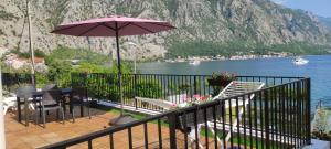 a balcony with a table and chairs and an umbrella at Beachfront Villa Nautica in Kotor