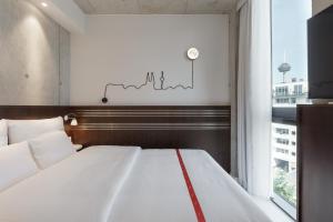 Una cama o camas en una habitación de Ruby Ella Hotel Cologne