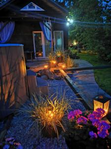 einen Garten im Hinterhof in der Nacht mit Licht und Blumen in der Unterkunft Green Garden house in Jūrmala